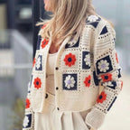 Woman wearing Garden Squares Crochet Cardigan in beige with navy and orange floral granny-square pattern