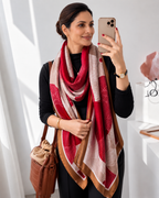 Woman wearing the Hafi Elegant Floral Silk Scarf in crimson red, ivory white and golden brown geometric floral print, styled as a luxurious imitation silk scarf by Westery Fashion House.  