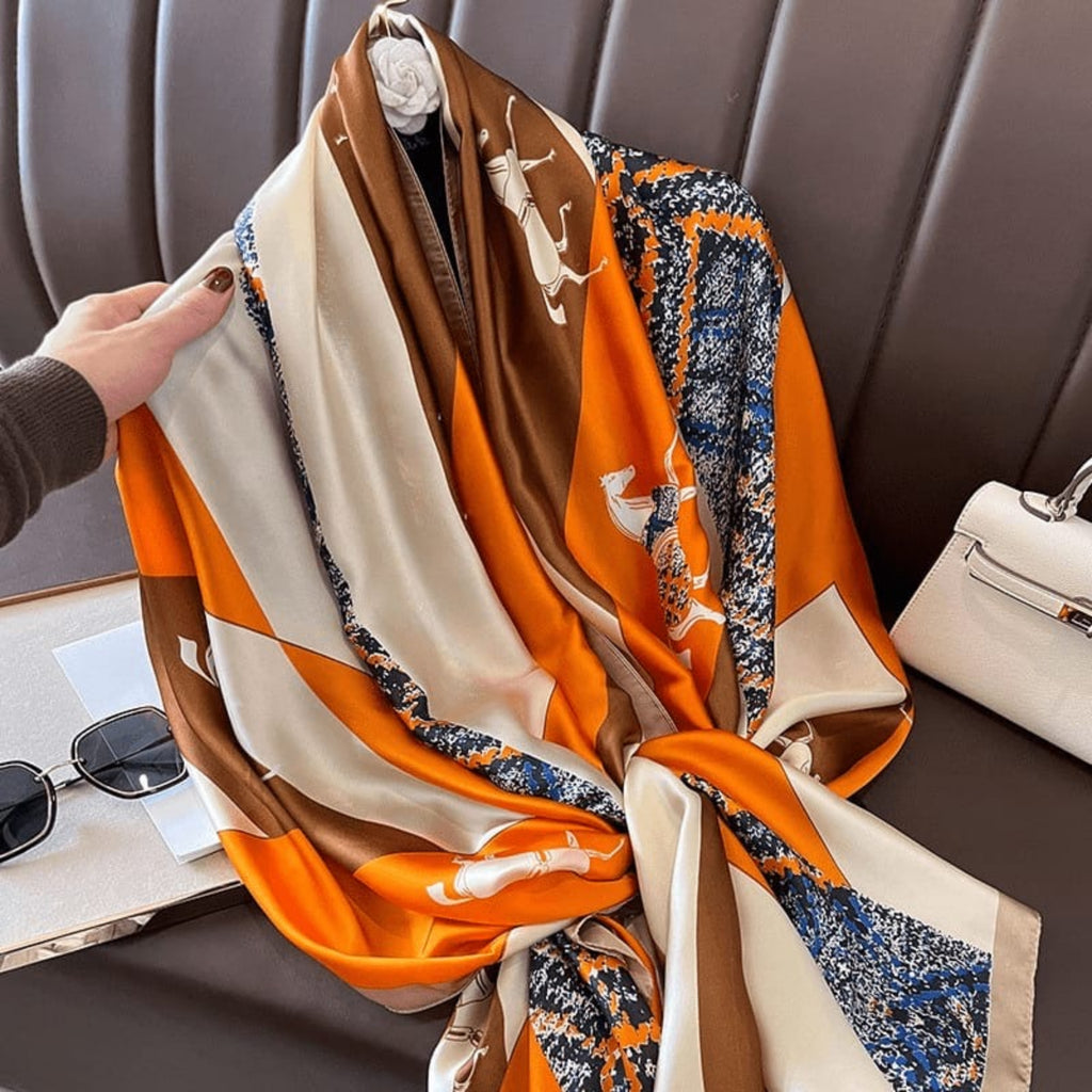 Hand holding equestrian horse print scarf - orange beige navy silk scarf with chain pattern border