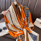 Hand holding equestrian horse print scarf - orange beige navy silk scarf with chain pattern border