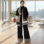 Woman wearing black houndstooth knit co-ord set with statement shawl