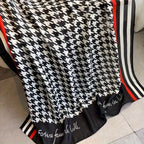 Close-up of houndstooth stole showing red stripe border and elegant text detail - viscose cotton fabric
