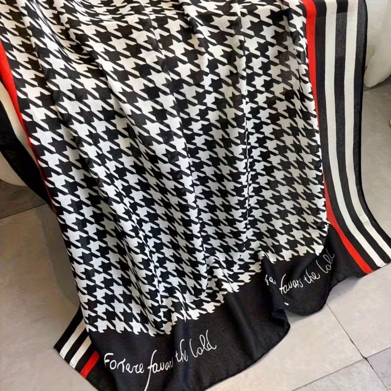 Close-up of houndstooth stole showing red stripe border and elegant text detail - viscose cotton fabric