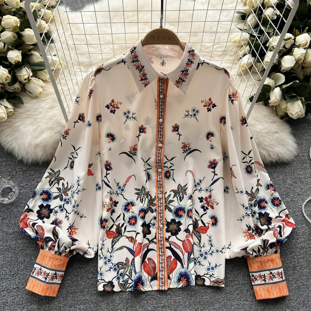 Jardin Bloom Satin Shirt displayed flat on hanger showing full botanical garden floral print with jewelled orange placket and contrast cuffs
