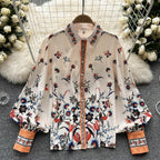 Jardin Bloom Satin Shirt displayed flat on hanger showing full botanical garden floral print with jewelled orange placket and contrast cuffs
