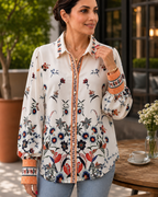 Close-up of woman wearing Jardin Bloom Satin Shirt showing botanical ombré floral print, pearl button placket, and orange contrast cuffs
