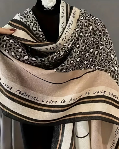 Close-up of leopard print stole showing French script text and elegant striped border