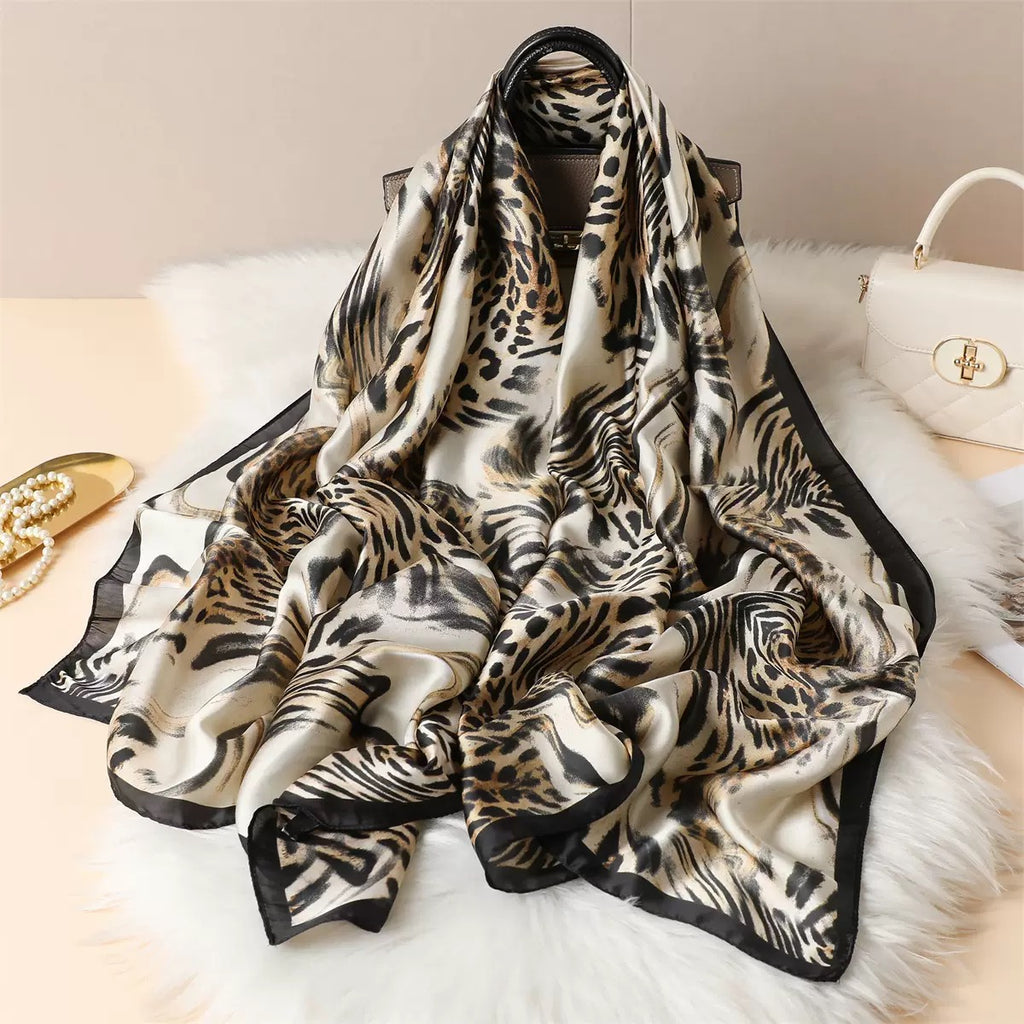 Luxe Savannah Silk Scarf loosely gathered showing full mixed animal print in cream black and gold with satin finish
