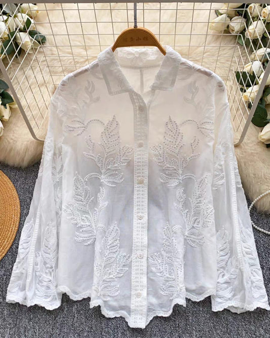 Luxe white linen blouse showing intricate floral embroidery and scalloped lace edges