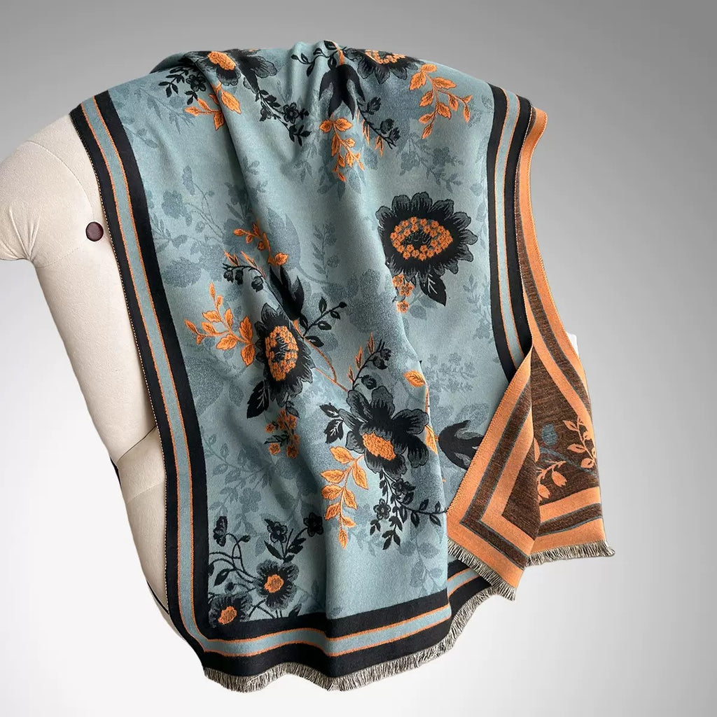 Luxury Reversible Oversized Floral Shawl Wrap laid flat showing full teal blue floral jacquard pattern with black and orange striped border and fringe hem
