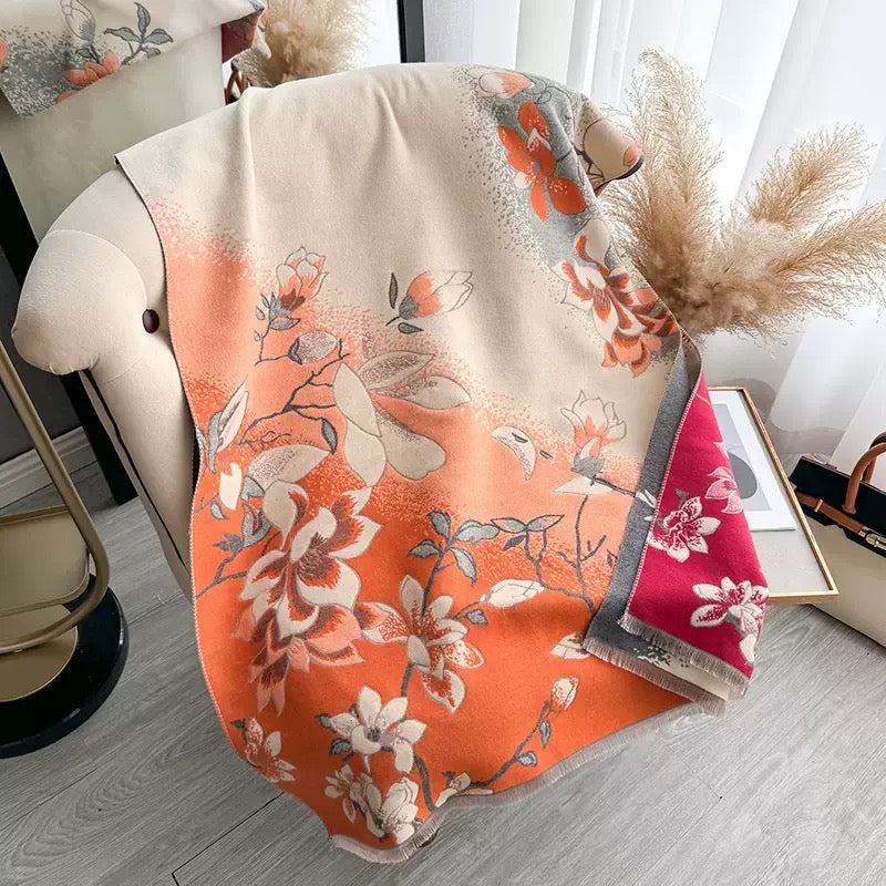 Magnolia Dusk Cashmere Stole draped over a chair showing the sunset orange magnolia floral side