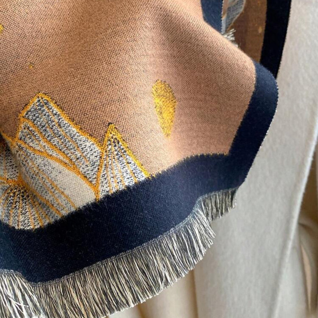 Close-up of Midnight Amber Black Shawl showing soft faux cashmere fabric texture with amber and gold leaf botanical print detail on black ground
