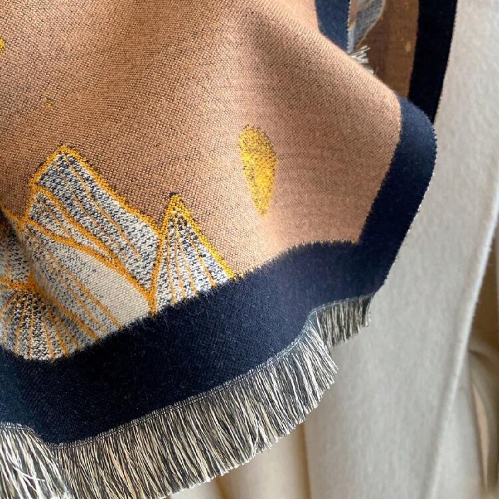 Close-up of Midnight Amber Black Shawl showing soft faux cashmere fabric texture with amber and gold leaf botanical print detail on black ground
