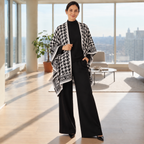 Woman wearing a black knit co-ord set with houndstooth statement wrap
