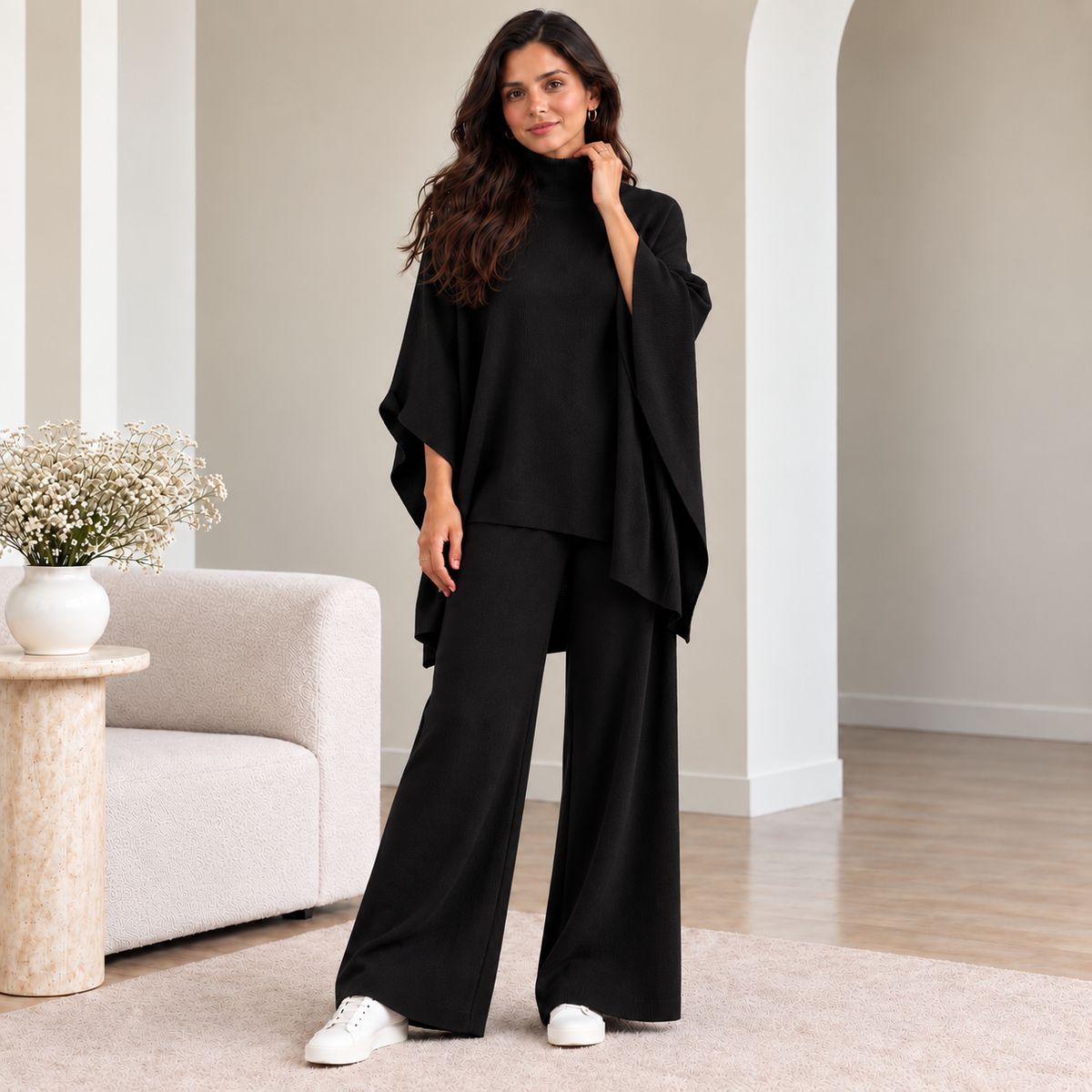 Woman wearing black turtleneck poncho knit co-ord set with wide-leg pants
