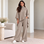 Woman wearing taupe turtleneck poncho knit co-ord set with wide-leg pants
