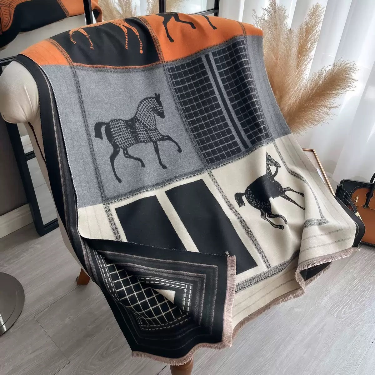 The Noir Equestrian Cashmere Wrap laid flat displaying full heritage equestrian print in contrasting tones on noir black faux cashmere fabric
