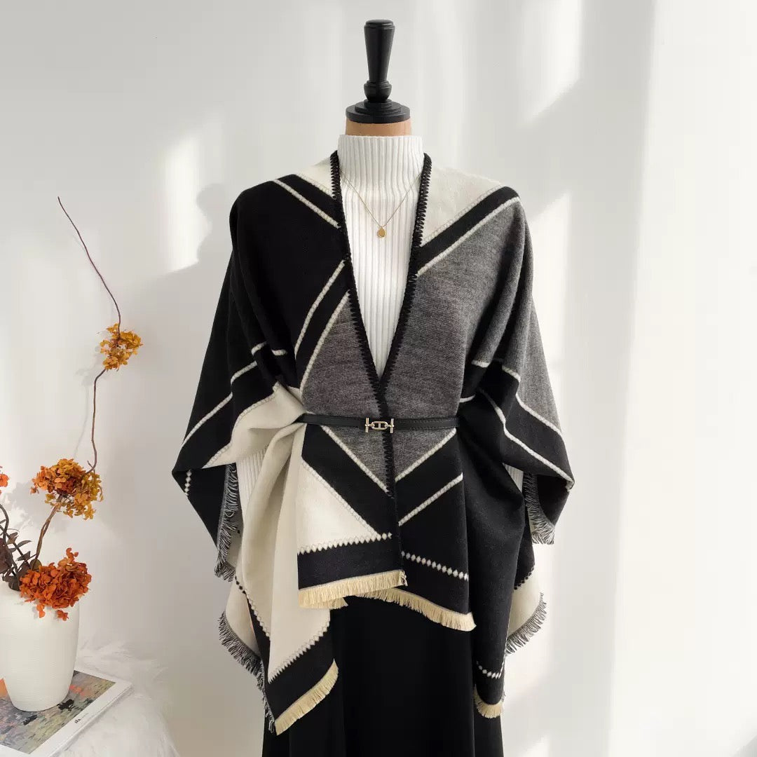 The Noir Geometry Cashmere Cape draped over shoulders in cape style showing geometric noir print and full-coverage silhouette

