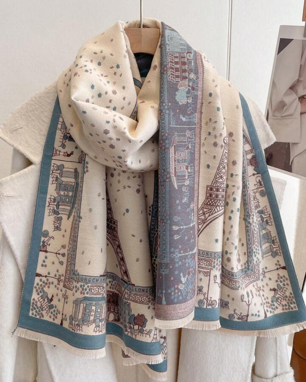 The Parisian Postcard Reversible Wrap draped and styled showing full vintage Parisian illustrated print on soft faux cashmere
