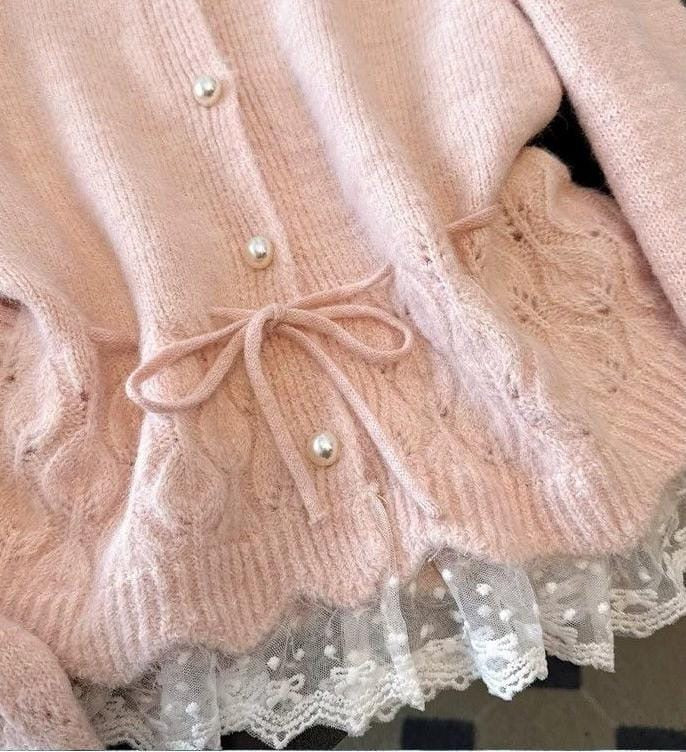 Close-up of the blush pink Rosé Belle Cardigan showing pearl-style buttons, waist tie and delicate lace trim