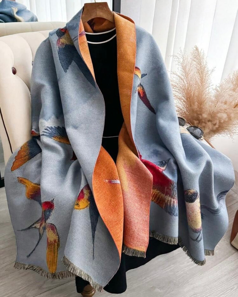 The Skybound Aviary Reversible Wrap showing primary side with nature-inspired aviary bird and botanical print on soft faux cashmere fabric
