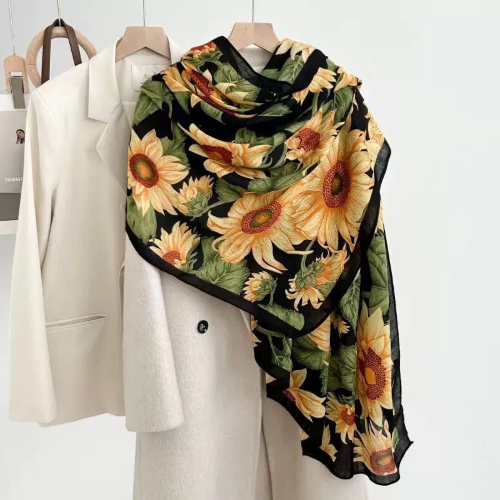 Sunflower print viscose cotton scarf in black with yellow sunflowers draped on mannequin - floral scarf styling