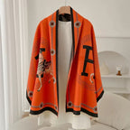     Reversible faux cashmere winter wrap featuring equestrian horse motif and elegant detailing.