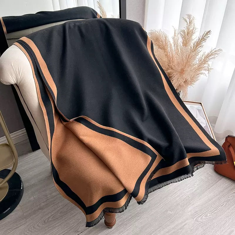     Luxurious The Signature Reversible Black & Tan Border Wrap draped on a chair, crafted from soft jacquard faux cashmere, size 182 x 65 cm.
