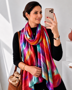Woman wearing a Vibrant Multicolor Abstract Feather Print Imitation Silk Stole in a stylish neck wrap. Rainbow-inspired red, pink, teal, purple and orange silk-feel scarf for women by Westery Fashion.  