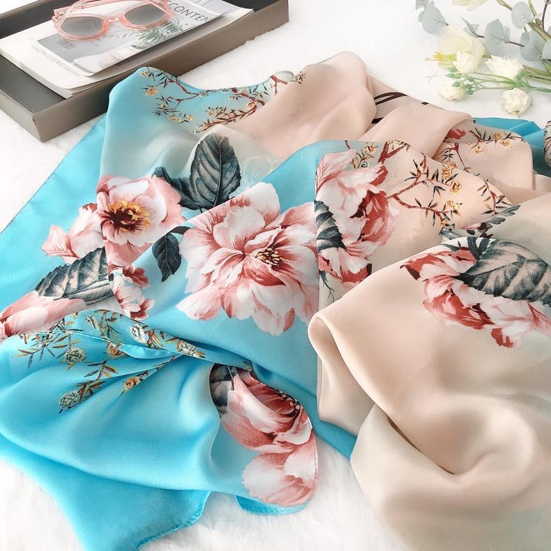 Close-up view of the draped Blooming Garden premium silk scarf by Westery, emphasizing the intricate botanical details, dark green foliage, delicate golden branches, and an illustrative butterfly motif.
