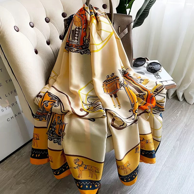 Westery Golden Carriage Equestrian premium silk scarf elegantly styled over a chair next to sunglasses and a luxury handbag, accentuating its classic vintage royal aesthetic.
