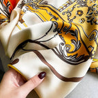 Close-up texture view of a hand holding the Westery Golden Carriage Equestrian premium silk stole, highlighting the soft fabric luster, delicate hand-rolled edges, and fine artwork details.

