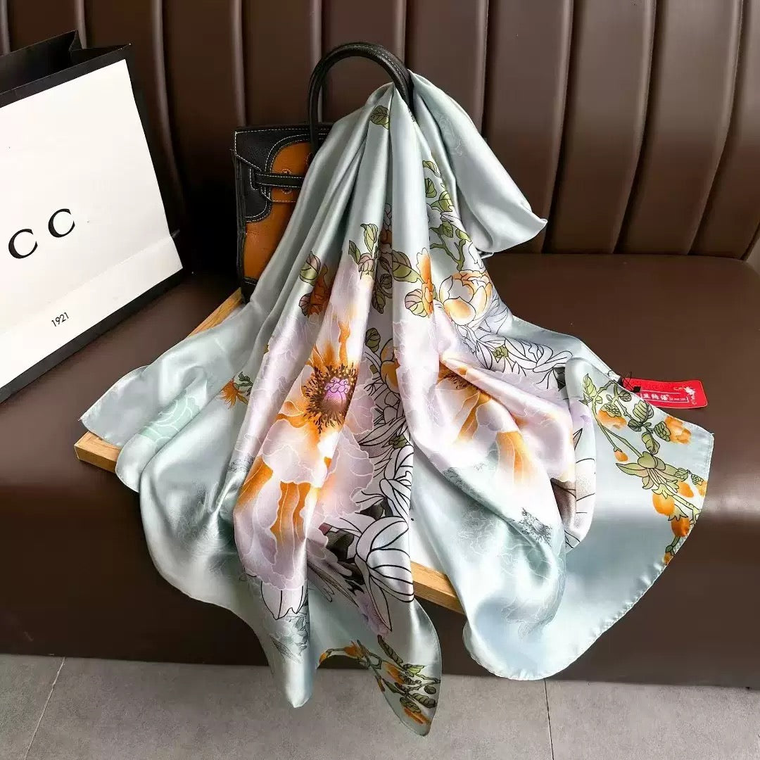 The Mint Blossom Garden luxury silk stole by Westery cascading elegantly from a display tray, highlighting the premium satin sheen, detailed flower line-art, and delicate fabric folds.
