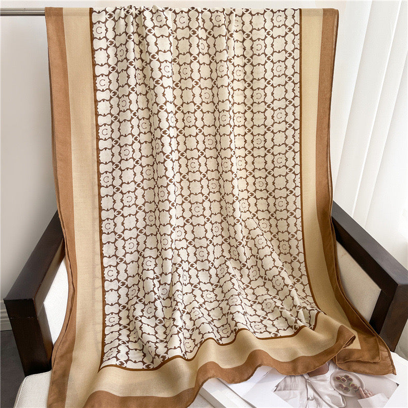 Full layout of the Westery Moroccan Lattice Luxe lightweight scarf draped symmetrically over an armchair, highlighting the clean structural design, multi-toned brown frames, and generous length.
