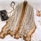 Moroccan Lattice Luxe premium viscose cotton stole by Westery displayed on a white surface next to a luxury black chain bag, showcasing its repeating tan geometric monogram pattern and elegant camel-toned borders.
