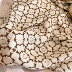 A close-up macro view of the Moroccan Lattice Luxe cotton viscose stole by Westery swirled into a tight rosette pattern, emphasizing the soft breathable weave and intricate tile print line-work.
