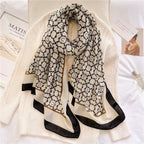 Noir Lattice Monogram premium viscose cotton stole by Westery draped over a white cable-knit sweater, showcasing its repeating black geometric tile pattern and bold contrast borders.
