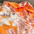 Close-up texture detail of the Sunkissed Lily luxury silk scarf by Westery, displaying the high-quality satin sheen and fine linework of the floral print.

