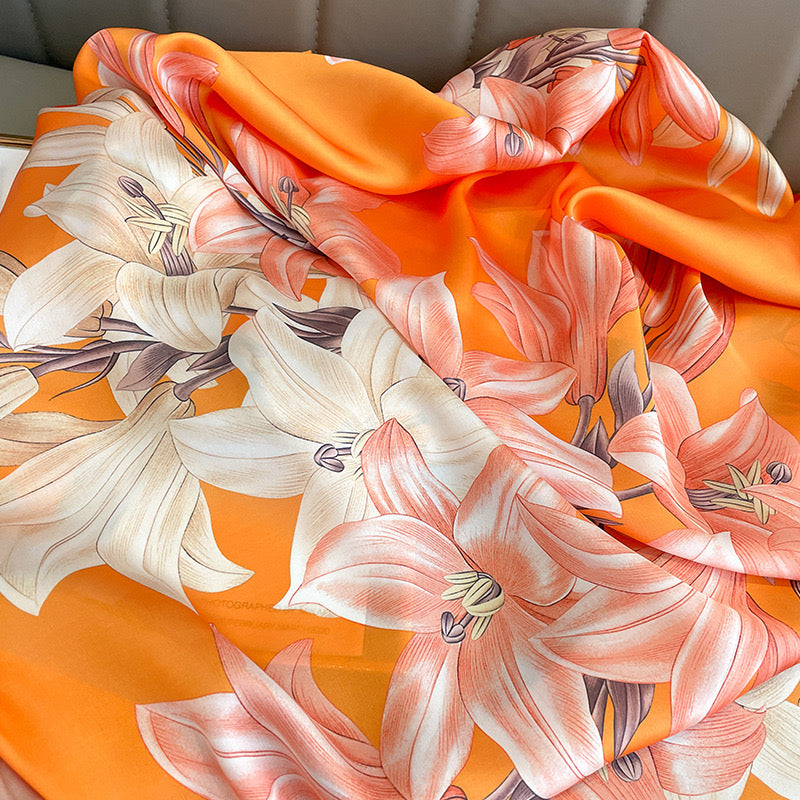 Close-up texture detail of the Sunkissed Lily luxury silk scarf by Westery, displaying the high-quality satin sheen and fine linework of the floral print.

