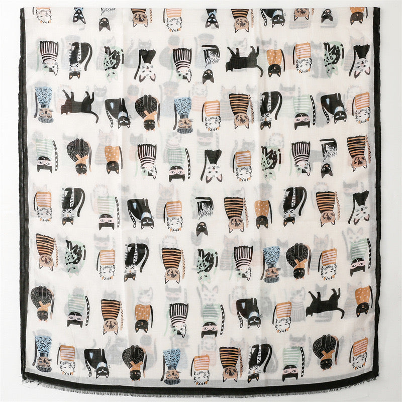 A close-up view of the Westery Whisker Tales lightweight cotton viscose scarf, highlighting the clean print details of quirky cartoon cats, the soft breathable fabric weave, and the delicate eyelash fringe edge finish.
