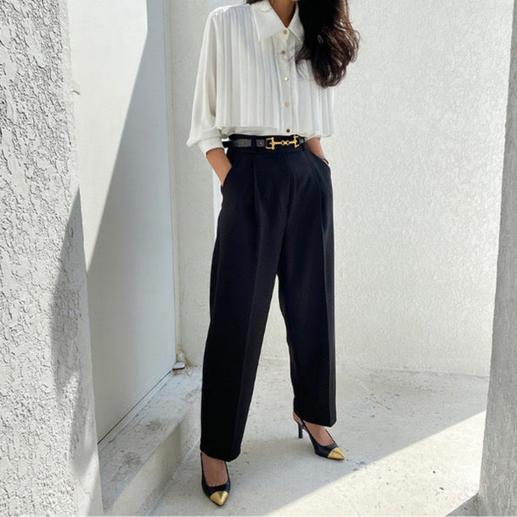 Side view of white pleated cape collar blouse on mannequin showing elegant drape and structure