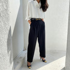 Side view of white pleated cape collar blouse on mannequin showing elegant drape and structure