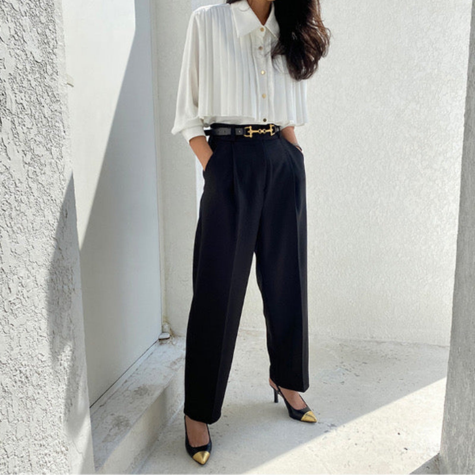 Side view of white pleated cape collar blouse on mannequin showing elegant drape and structure