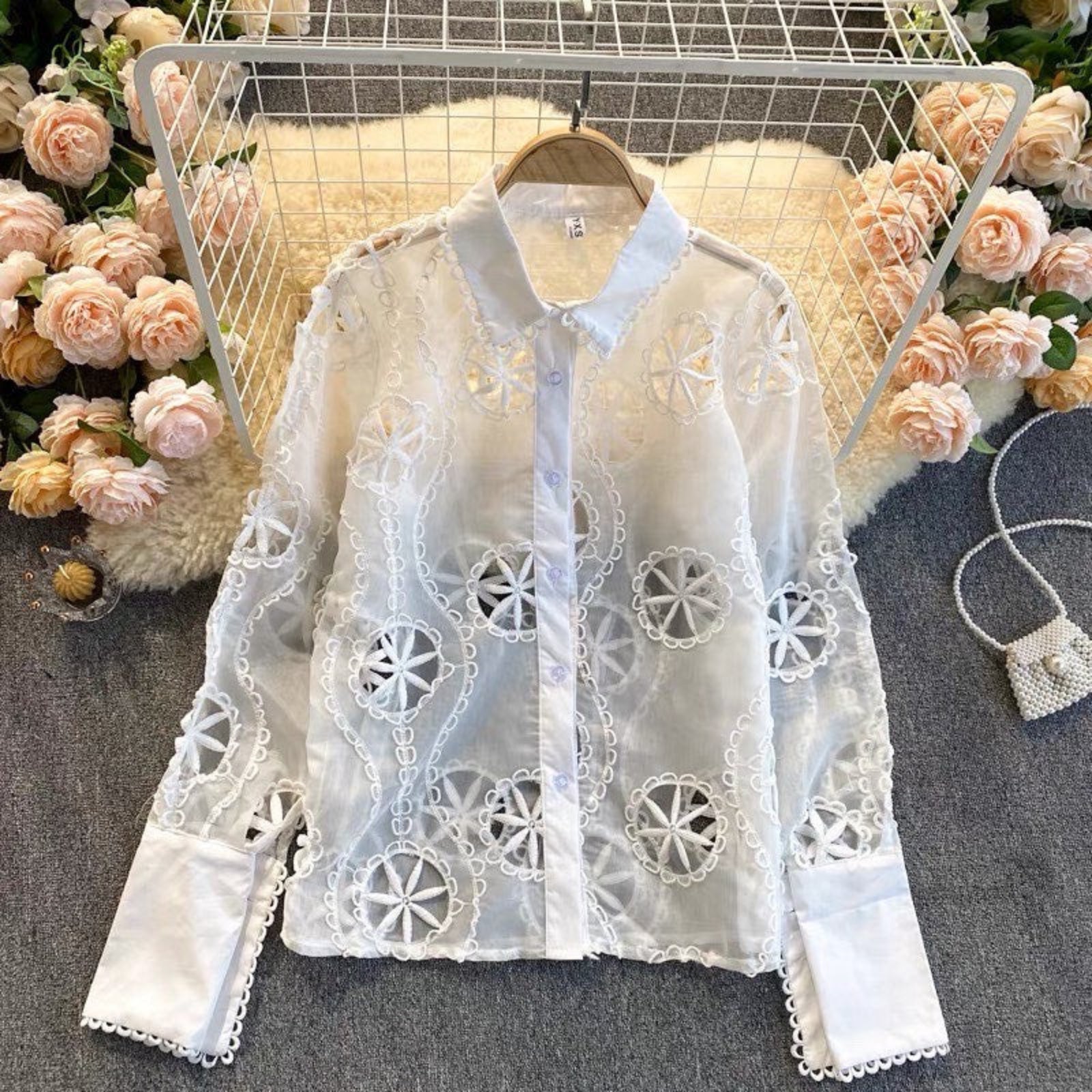 Vibe Eyelet Statement Shirt displayed on hanger showing crochet lotus eyelet pattern and button front
